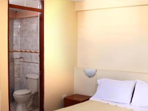 Habitación con baño con cama y aseo. en Hostal Lucerito, en Cusco