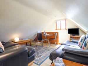 ein Wohnzimmer mit einem Sofa und einem Tisch in der Unterkunft The Studio, Horseshoe Cottage in Fulbourn