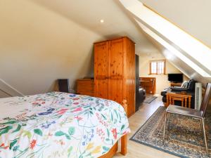 Schlafzimmer mit einem Bett, einer Kommode und einem Schreibtisch in der Unterkunft The Studio, Horseshoe Cottage in Fulbourn