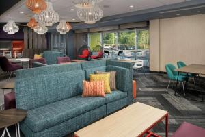 a living room with a couch and tables and chairs at Tru By Hilton Mt Pleasant Charleston in Charleston