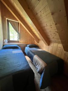 a room with three beds in a attic at Casa Cantone Devero-baita storica con balcone e giardino, posizione comoda e soleggiata- spazio biciclette in Alpe Devero
