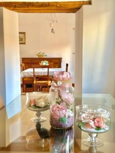 une table avec trois vases en verre remplis de roses roses dans l'établissement Royal Domus Perugia - via Mazzini, à Pérouse