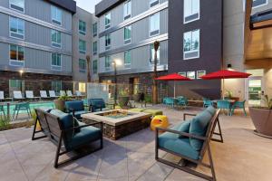 a patio at a hotel with chairs and a fire pit at Home2 Suites By Hilton Temecula in Temecula