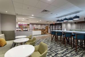 a waiting room with tables and chairs and a counter at Hampton Inn Madison, OH in Madison