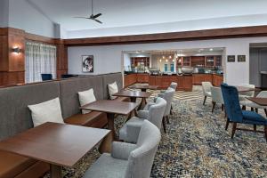 a restaurant with tables and chairs and a kitchen at Homewood Suites by Hilton College Station in College Station