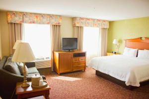ein Hotelzimmer mit einem Bett und einem TV in der Unterkunft Hampton Inn & Suites College Station in College Station