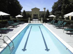 a swimming pool with lounge chairs and umbrellas at DoubleTree by Hilton Charlotte Airport in Charlotte