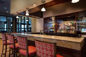 um bar com um monte de cadeiras e um balcão de bar em DoubleTree by Hilton Charlotte Airport em Charlotte