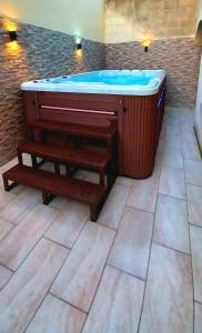 une grande baignoire avec un banc à côté dans l'établissement Luxurious apartment with heated pool jacuzzi, 