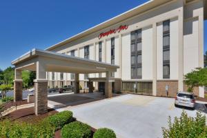 a hotel building with a car parked in a parking lot at Hampton Inn Charlotte North Lake Norman in Cornelius