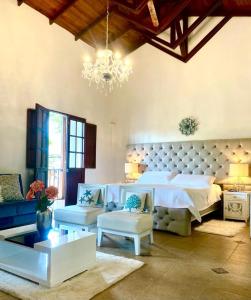 Habitación grande con cama y lámpara de araña. en Hotel Colonial Andino - Parque principal de Pitalito, en Pitalito