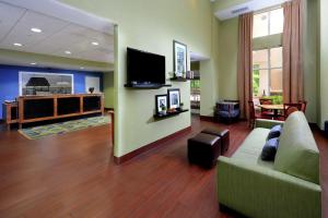 sala de estar con sofá y TV de pantalla plana en Hampton Inn & Suites Huntersville en Huntersville