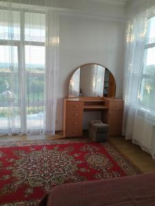 a room with a mirror and a dresser and windows at Вілла Сади Єви in Lyubintsy