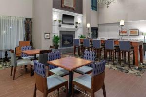 a restaurant with tables and chairs and a fireplace at Hampton Inn & Suites Concord-Charlotte in Concord