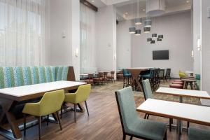 a dining room with tables and chairs at Hampton Inn & Suites Charlotte Airport Lake Pointe in Charlotte