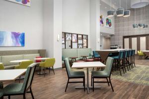 uma sala de jantar com mesas e cadeiras em Hampton Inn & Suites Charlotte Airport Lake Pointe em Charlotte