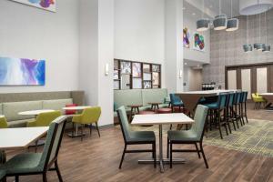 a dining room with tables and chairs at Hampton Inn & Suites Charlotte Airport Lake Pointe in Charlotte