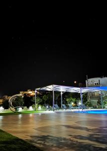 a white pavilion with chairs under it at night at Nina Apartment in Chania Town