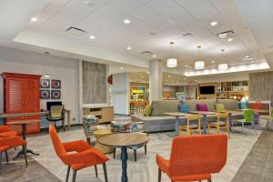 um átrio com um sofá, mesas e cadeiras em Home2 Suites By Hilton Charlotte Piper Glen em Charlotte