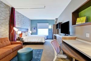Habitación de hotel con cama y TV en Home2 Suites By Hilton Charlotte Piper Glen en Charlotte