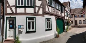 um edifício com janelas verdes e brancas numa rua em Altstadtglück Seligenstadt em Seligenstadt