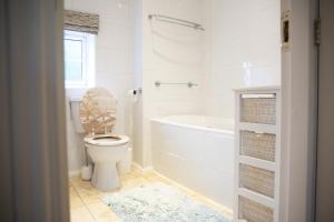 a white bathroom with a toilet and a bath tub at Beautiful House in Stratford upon Avon in Stratford-upon-Avon