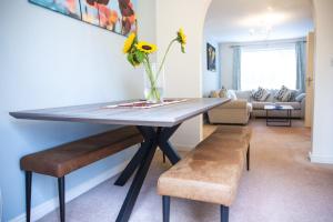 a dining room table with a vase of flowers on it at Beautiful House in Stratford upon Avon in Stratford-upon-Avon