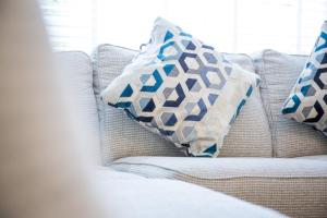 a white couch with two pillows on it at Beautiful House in Stratford upon Avon in Stratford-upon-Avon +19 photos