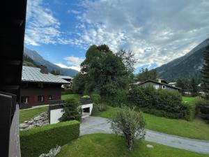 vistas a un patio con una casa y montañas en Appartement 6 personnes les Contamines Montjoie en Les Contamines-Montjoie