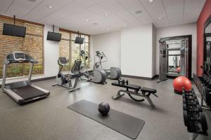 a gym with several exercise equipment in a room at Hilton Garden Inn Charlotte Airport in Charlotte
