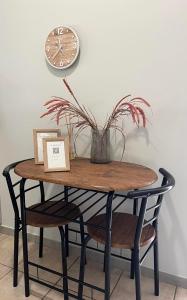 een tafel met een plant en een klok op een muur bij Póe home Trikala in Tríkala