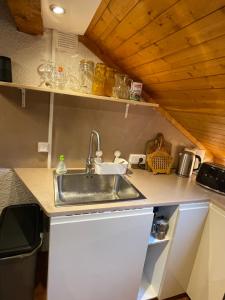una cocina con fregadero en una casa pequeña en Appartement 6 personnes les Contamines Montjoie en Les Contamines-Montjoie