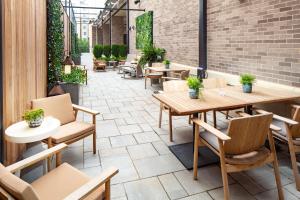 an outdoor patio with tables and chairs and plants at Canopy By Hilton Charlotte SouthPark in Charlotte