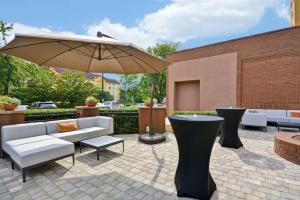 a patio with a couch and an umbrella at Embassy Suites Charlotte in Charlotte