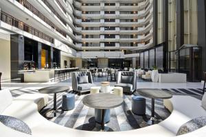 a lobby with tables and chairs and a building at Embassy Suites Charlotte in Charlotte