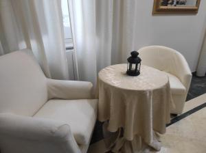 um quarto com duas cadeiras e uma mesa com uma vela em Interno 12 - L'Aquila em LʼAquila