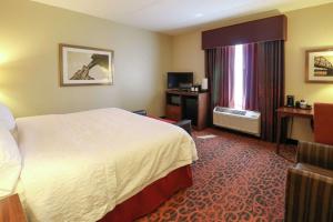 a hotel room with a bed and a television at Hampton Inn Columbus-South in Grove City