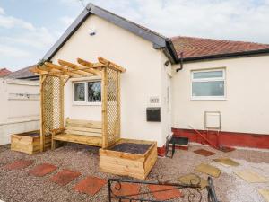 a wooden pergola in front of a white house at 5 Woodside Avenue in Rhyl
