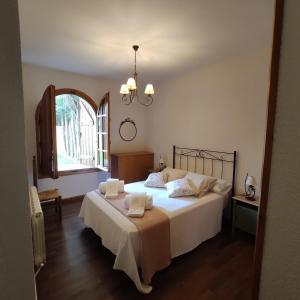 a bedroom with a large white bed with a window at EL COBIJO in Mojados