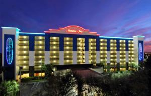 Un edificio de hotel con un cartel encima. en Hampton Inn Cocoa Beach, en Cocoa Beach