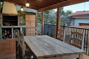 een houten tafel en stoelen op een terras bij Piso con preciosas vistas, patio privado y amplio garaje in Puentedeume