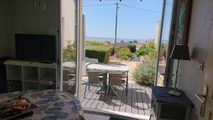 a balcony with a view of a patio with a television at La campagne a la mer in Piédemont