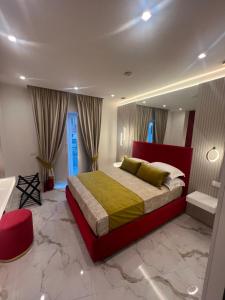 um quarto com uma cama grande e uma cabeceira vermelha em La Lepre Artemide em Nápoles