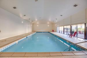 a large swimming pool with blue water in a building at Grand Junction Vacation Rental Indoor Pool Access in Grand Junction