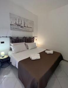 a bedroom with a large bed with two towels on it at Sassari Apartments - Maestrale in Sassari