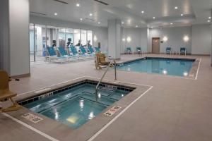 Una gran piscina en una habitación de hospital con sillas. en Hilton Garden Inn Colorado Springs Downtown, Co, en Colorado Springs