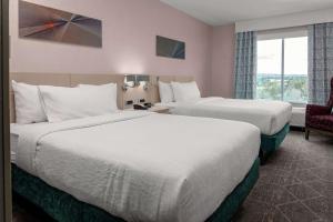 una habitación de hotel con dos camas y una silla en Hilton Garden Inn Colorado Springs Downtown, Co, en Colorado Springs 31 fotos más