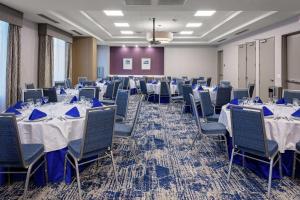 uma sala de banquetes com mesas e cadeiras com guardanapos azuis em Hilton Garden Inn Colorado Springs Downtown, Co em Colorado Springs