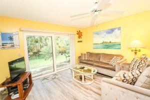圣奥古斯丁St Augustine Beach & Tennis Resort 1002的客厅里有一张沙发和一台电视