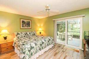 圣奥古斯丁St Augustine Beach & Tennis Resort 1002的一间卧室，里面有一张床和一扇推拉玻璃门 更多14张照片